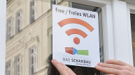 Schild an einer Fensterscheibe mit der Aufschrift "free WLAN"