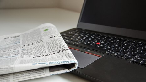 Zeitung, die auf einem Laptop liegt